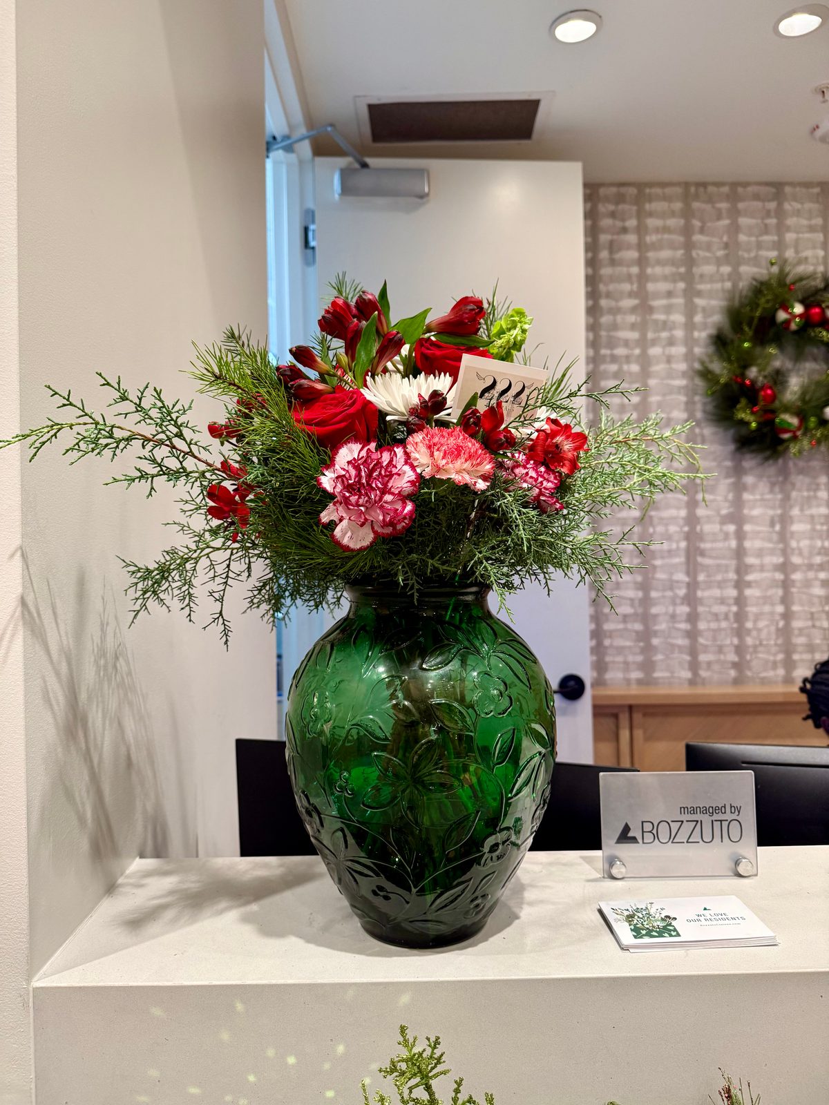 Holiday red and pink arrangement in green vase