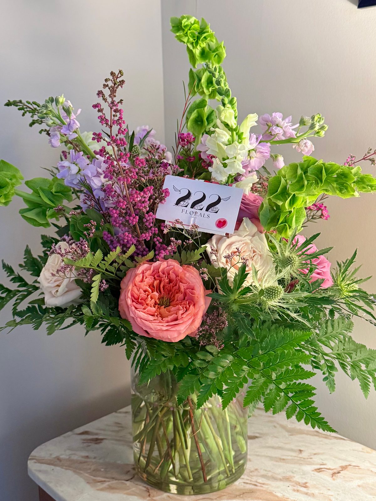 Spring garden roses with bells of Ireland and ferns