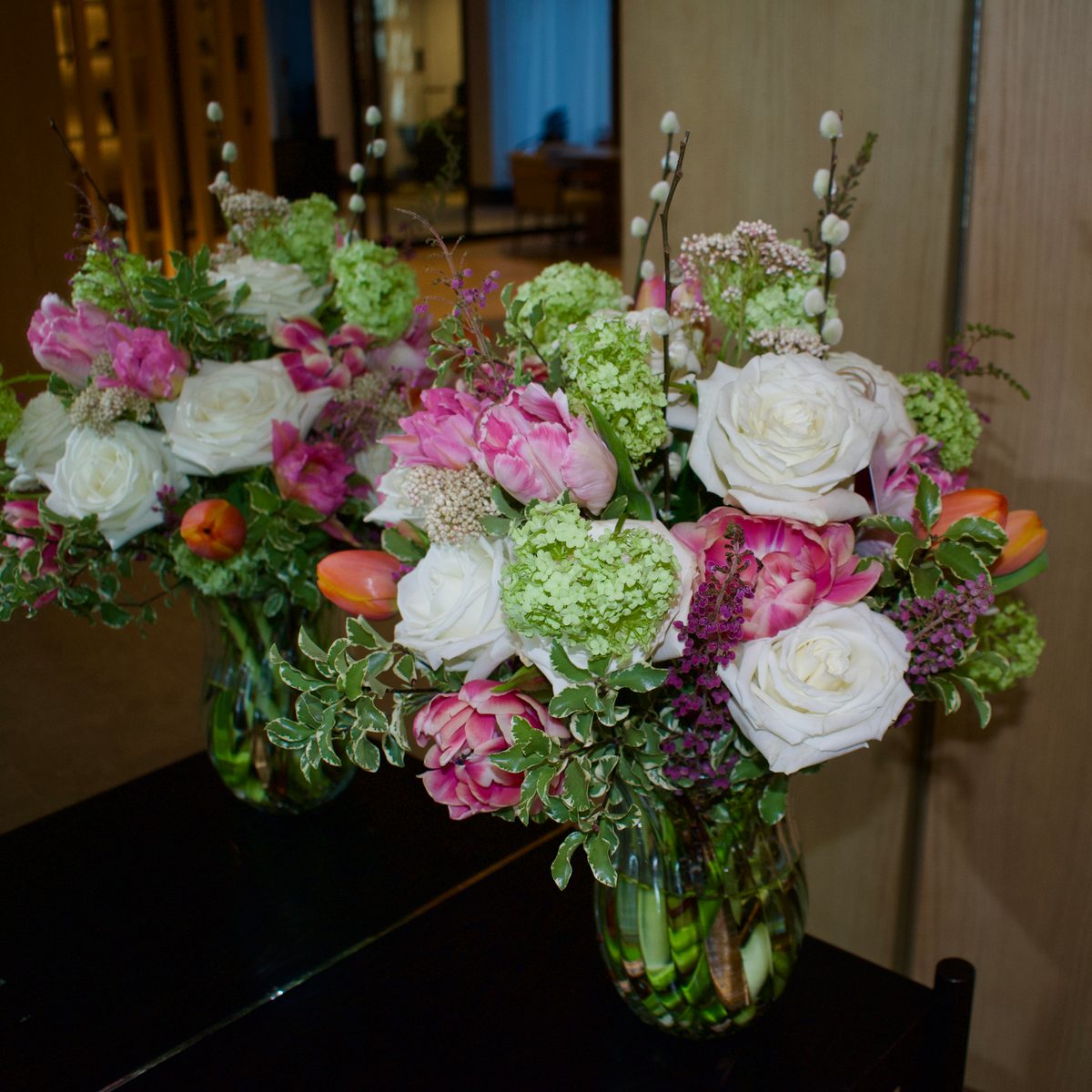 Vase arrangement of white garden roses, pink parrot tulips and green viburnum